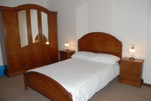 1 dormitorio con 1 cama grande de madera y 2 mesitas de noche en Apartamento Tatiana, en Seia