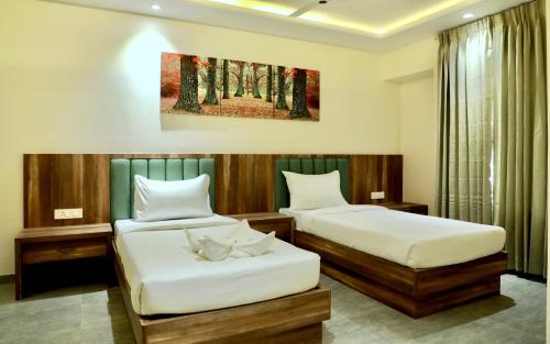 a hotel room with two beds and a window at The Grand Imperial in Pune