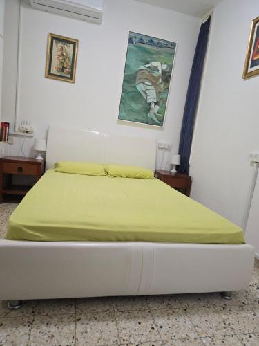 a bedroom with a bed with a yellow blanket on it at Ein Gedi Family Apartment in Ein Gedi