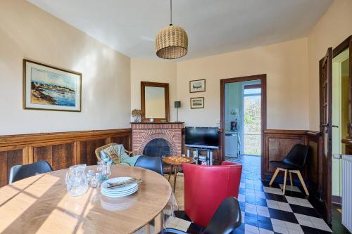 un salon avec une table et une cheminée dans l'établissement Villa Les Mouettes - A 50 m de la plage, à Bernières-sur-Mer