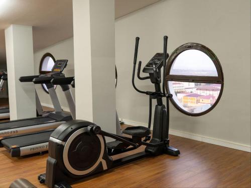 a gym with two tread machines and a mirror at Nafta Sanatorium in Naftalan
