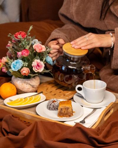a table with a plate of cake and a cup of coffee at Nafta Sanatorium in Naftalan