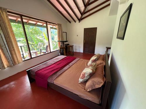 a large bed in a room with a large window at Moban House in Diyatalawa
