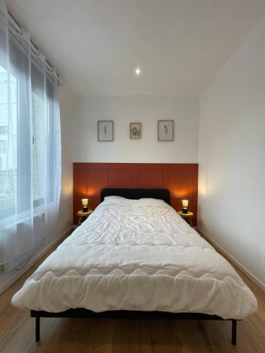 une chambre avec un grand lit blanc avec deux lampes dans l'établissement La belle mine, à Lens