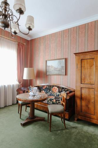 a living room with a table and a couch at Romantik Hotel zur Post in Fürstenfeldbruck
