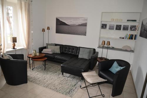 a living room with a black couch and chairs at Casa Felice by Fewotessin in Brissago