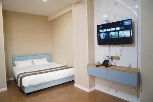 a bedroom with a bed and a tv on the wall at Misoko hotel in Ulaanbaatar
