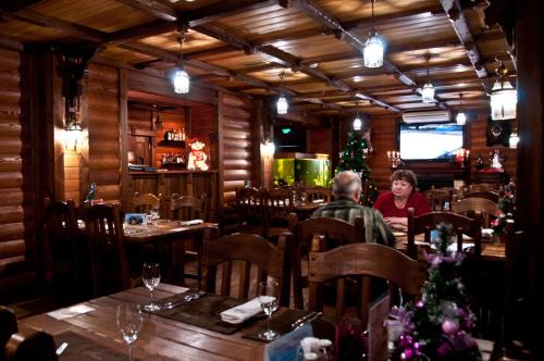 a man and a woman sitting at a table in a restaurant at Hotel Misne in Khanty-Mansiysk