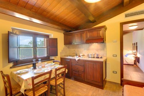 eine Küche mit einem Tisch mit Stühlen und einem Waschbecken in der Unterkunft Azienda Agrituristica Le Bucoliche in Osimo