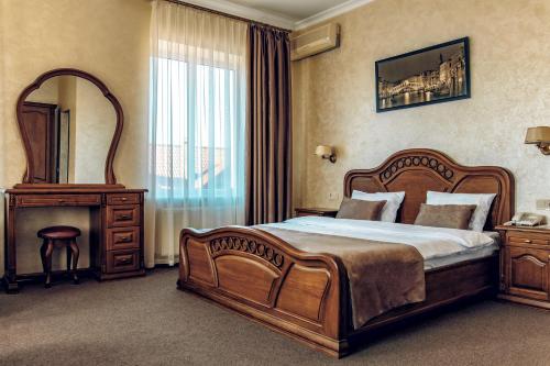 een slaapkamer met een groot houten bed en een spiegel bij Veles Hotel in Fontanka