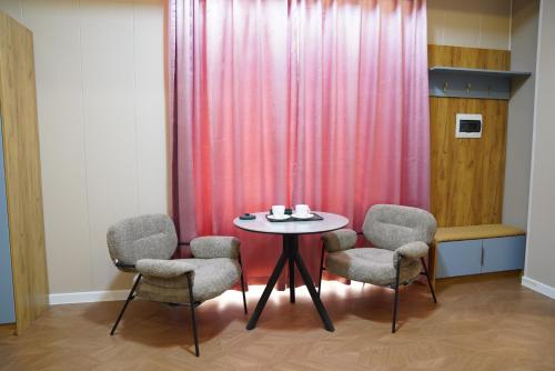 a table with four chairs and a pink curtain at Misoko hotel in Ulaanbaatar