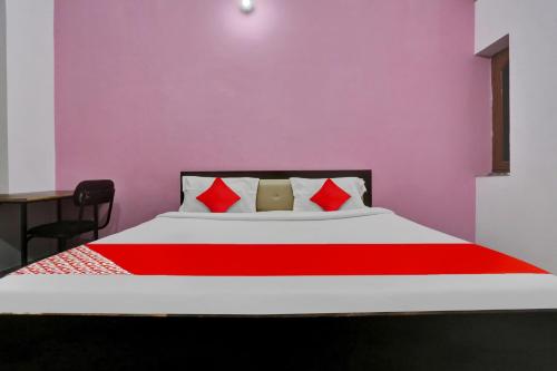 a bedroom with a large bed with red pillows at Hotel O Hotel Royal Palace in Meerut