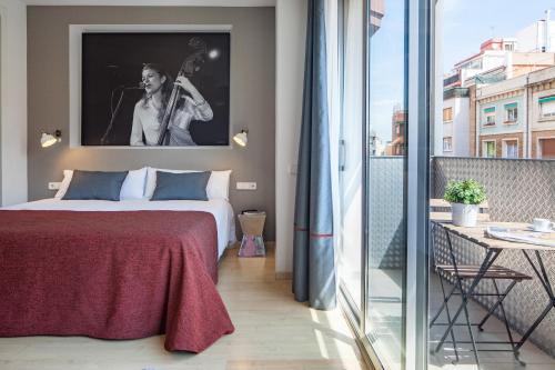 sypialnia z łóżkiem i zdjęciem mężczyzny grającego na gitarze w obiekcie Habitat Apartments Hot Jazz w Barcelonie