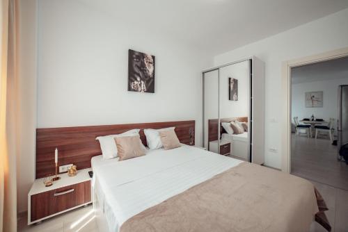 a bedroom with a large bed with a wooden headboard at CozyCollection Apartments at Q Residence #6 in Iaşi