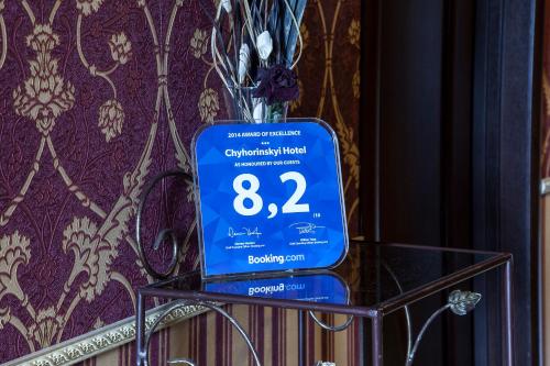 una señal azul en una mesa de cristal con un jarrón en Chyhorinskyi Hotel en Kiev