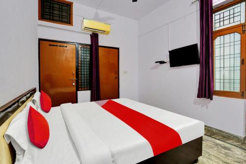 a bedroom with a bed with a red and white at Hotel O Hotel Royal Palace in Meerut