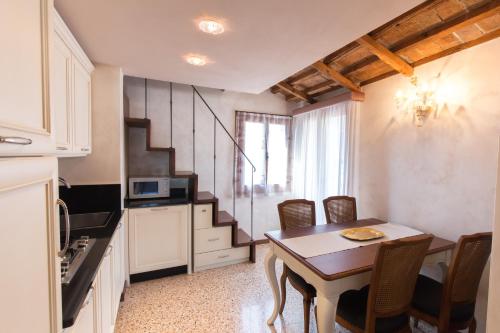 ヴェネツィアにあるCà Manzoni Apartment with Terraceのキッチン、ダイニングルーム(テーブル、椅子付)