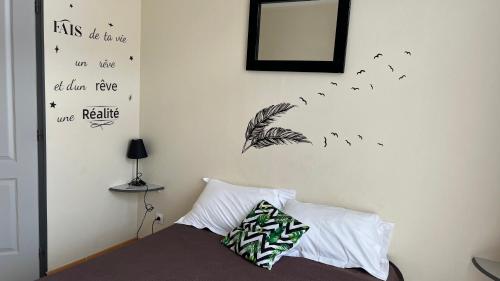 a bedroom with a bed with a mirror and feathers on the wall at Le Signoret in Sault-de-Vaucluse