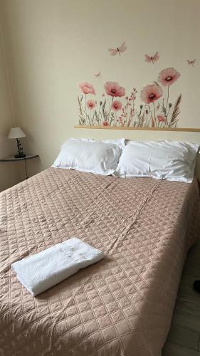 a bedroom with a bed with pink flowers on the wall at Le Signoret in Sault-de-Vaucluse