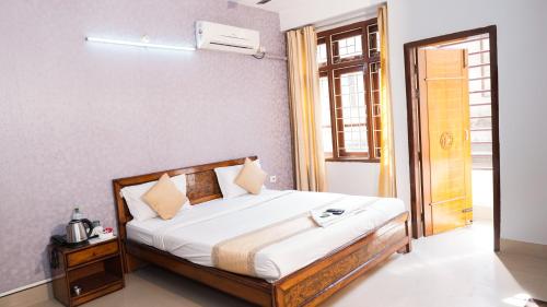 a bedroom with a bed and a window at Hotel Royal Beltola in Guwahati
