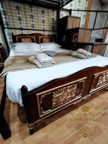 a large wooden bed with white sheets and towels on it at Jessica Flat Malta Royal Guesthouse in Cospicua