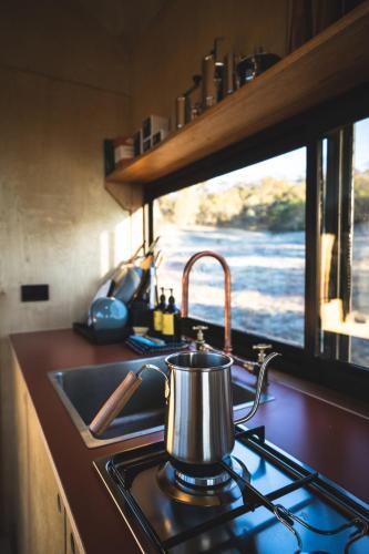a tea kettle on a stove in a kitchen at Remote Off-Grid Cabin in the Wilderness - Jude in Warrenmang