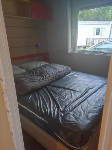 un petit lit dans une chambre avec une fenêtre dans l'établissement Mobil home 6 personnes, à Boofzheim