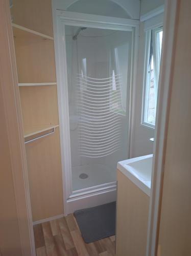 une douche en verre dans une salle de bain avec un lavabo dans l'établissement Mobil home 6 personnes, à Boofzheim