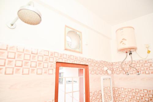 a mirror in a room with a wall with tiles at Hotel Royal Beltola in Guwahati