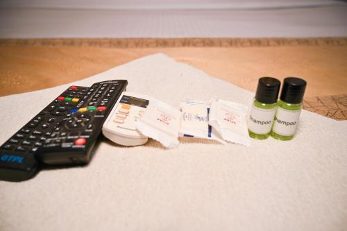a remote control sitting next to two bottles of medicine at Hotel Royal Beltola in Guwahati