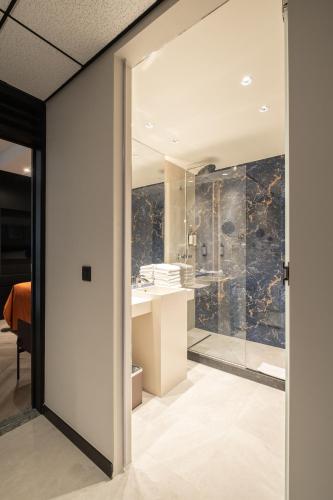 un baño con ducha y lavabo en Hyllit Hotel, en Amberes