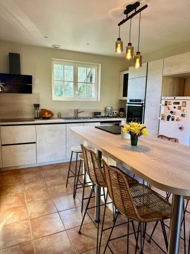 une cuisine avec une grande table et des chaises en bois dans l'établissement Le hameau Maison de Campagne, à Varengeville-sur-Mer