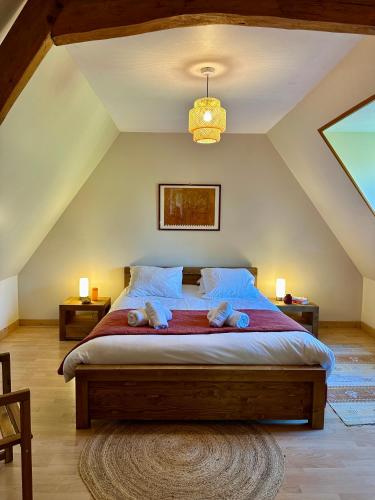 une chambre avec un grand lit dans un grenier dans l'établissement Le hameau Maison de Campagne, à Varengeville-sur-Mer