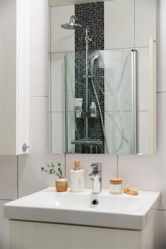 a white bathroom with a sink and a mirror at Apartament u Isabelli in Jeżów