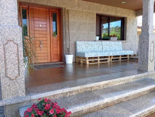 a porch with a bench in front of a door at A Eira de Salvador in Portas
