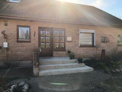 a brick house with stairs leading to a door at Lorenz große FeWo mit sonnigem Balkon in ruhiger Lage in Silberstedt