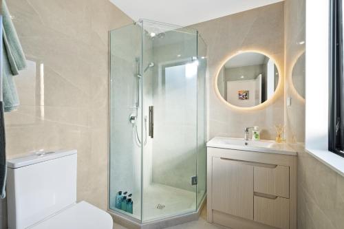 a bathroom with a shower and a toilet and a sink at Luxury 4 BR Retreat 4 bath with 3 Master Suites and Kids' Playroom in Auckland