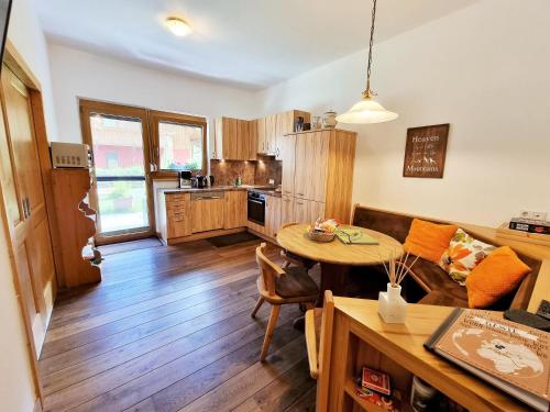 a kitchen and living room with a table and a couch at Appartement Berghof "Dettis Place" in Gerlos