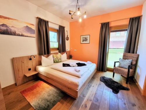 a bedroom with a bed and a chair in it at Appartement Berghof "Dettis Place" in Gerlos