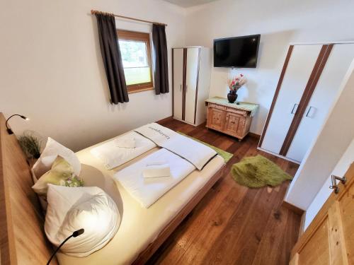 a room with a bed and a television in it at Appartement Berghof "Dettis Place" in Gerlos