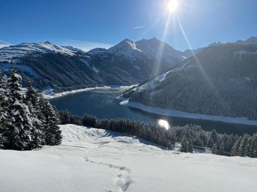 a view of a lake in the mountains with the sun at Appartement Berghof "Dettis Place" in Gerlos