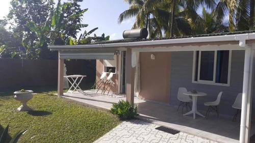 una casa con patio arredato con sedie e tavolo di Bungalow confortable à Sainte-Rose avec jardin privé_222 a Sainte-Rose