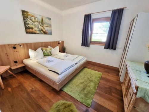 a bedroom with a bed with a green rug at Appartement Berghof "Dettis Place" in Gerlos
