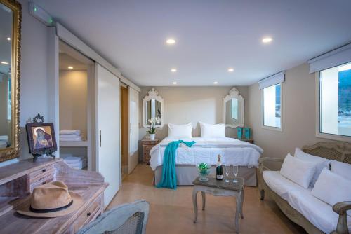 a hotel room with a bed, table and chairs at Parthenis Beach, Suites by the Sea in Malia