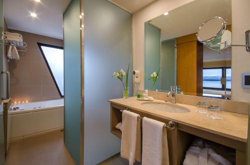 a bathroom with a sink and a mirror at NH Bariloche Edelweiss in San Carlos de Bariloche