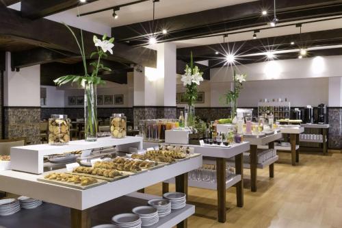 a bakery with several tables filled with pastries at NH Bariloche Edelweiss in San Carlos de Bariloche