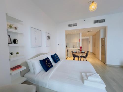 a large white bed in a room with a table at Cosy Studio in Yas Island, Abu Dhabi in Abu Dhabi