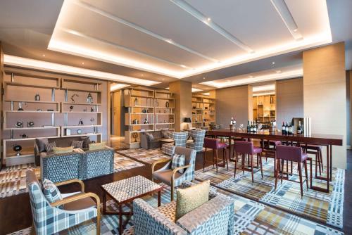 a restaurant with a bar and tables and chairs at Hyatt Regency Lucknow Gomti Nagar in Lucknow