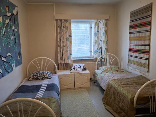 a room with two beds and a window at OuluHostel AlliMaria in Oulu
