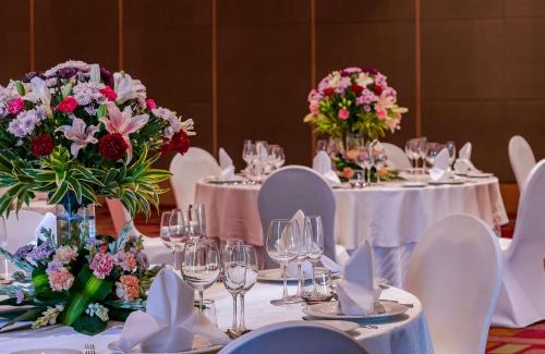 a table with white tables with flowers on them at Hyatt Regency Lucknow Gomti Nagar in Lucknow